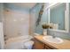 Bright bathroom with white tiled shower/tub, light blue walls, decorative vase, and single sink at 2552 Stonewall Ln, Lafayette, CO 80026