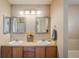 Bright bathroom with double sinks, decorative mirrors, and wood cabinets with ample counter space at 2552 Stonewall Ln, Lafayette, CO 80026