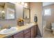 Well-lit bathroom with dual sinks, wooden cabinets, and large mirrors above each sink at 2552 Stonewall Ln, Lafayette, CO 80026