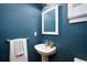 Stylish half bathroom featuring vibrant blue walls, a pedestal sink, and a modern mirror at 2552 Stonewall Ln, Lafayette, CO 80026
