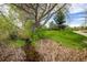 Peaceful greenspace featuring lush vegetation, a small stream, and mature trees, perfect for relaxation and nature walks at 2552 Stonewall Ln, Lafayette, CO 80026