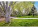 Scenic view of a community greenspace with mature trees, a small bridge, and walking paths at 2552 Stonewall Ln, Lafayette, CO 80026