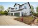Exterior of a home with three-car garage, green doors and a well-maintained lawn at 2552 Stonewall Ln, Lafayette, CO 80026