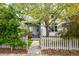 Charming home exterior featuring a well-manicured lawn, mature tree, and inviting white picket fence at 2552 Stonewall Ln, Lafayette, CO 80026