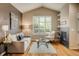 Inviting living room with vaulted ceiling, a cozy fireplace, and natural light from large window at 2552 Stonewall Ln, Lafayette, CO 80026