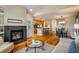 Open-concept living space with fireplace, modern kitchen, dining area, and hardwood floors at 2552 Stonewall Ln, Lafayette, CO 80026