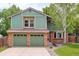 Charming two-story home with a well-manicured lawn, a two-car garage, and classic brick and siding exterior at 10966 W Half Moon Pass, Littleton, CO 80127