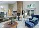 Inviting living room featuring a brick fireplace and large windows at 10966 W Half Moon Pass, Littleton, CO 80127