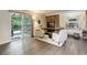 Inviting living room features a brick fireplace, hardwood floors, and sliding glass doors to outdoor living at 10966 W Half Moon Pass, Littleton, CO 80127