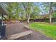 Spacious backyard with mature trees, garden beds, a wooden fence, and stone patio at 5405 S Lowell Blvd, Littleton, CO 80123