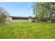 View of the home's backyard featuring a green lawn and covered patio at 5405 S Lowell Blvd, Littleton, CO 80123