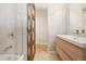 Bathroom featuring white tiles, a wood door, and a light wood vanity with a white countertop at 5405 S Lowell Blvd, Littleton, CO 80123