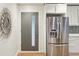 Home entryway with a steel front door, sunburst mirror, and stainless steel refrigerator at 5405 S Lowell Blvd, Littleton, CO 80123