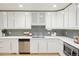 Well-lit kitchen with sleek white cabinets, stainless steel appliances, and gray backsplash at 5405 S Lowell Blvd, Littleton, CO 80123