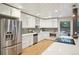 Open kitchen design with stainless steel appliances, white cabinets, and hardwood floors at 5405 S Lowell Blvd, Littleton, CO 80123