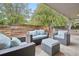 Covered patio with comfortable outdoor seating surrounded by lush greenery and a wooden fence at 5405 S Lowell Blvd, Littleton, CO 80123