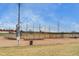 Well-maintained baseball field featuring bleacher seating and tall netting with a view of powerlines at 4671 S Decatur St # 232, Englewood, CO 80110