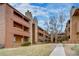 Apartment building with wood paneling and stone masonry with trees and grass at 4671 S Decatur St # 232, Englewood, CO 80110