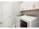 Well-organized laundry room with modern washer and dryer, plus ample cabinet space at 20968 E 60Th Pl, Aurora, CO 80019