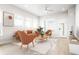 Bright living room with an orange couch and chairs, with natural light coming from the windows at 20968 E 60Th Pl, Aurora, CO 80019