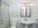 Bright bathroom with classic fixtures, including a pedestal sink, toilet, and tiled shower, showcasing clean, simple design at 805 Columbine Rd # 105, Breckenridge, CO 80424