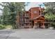 Inviting lodge exterior with wood facade, stone accents, entryway portico and hanging floral baskets at 805 Columbine Rd # 105, Breckenridge, CO 80424
