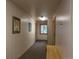 Hallway with white wooden-paneled walls, carpeted floor, artwork, windows and a bench at 805 Columbine Rd # 105, Breckenridge, CO 80424