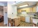 Functional kitchen featuring a breakfast bar, plenty of cabinetry, and white appliances at 805 Columbine Rd # 105, Breckenridge, CO 80424
