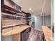 Basement bar with rustic wood shelving and a reclaimed wood feature wall at 24589 E Louisiana Cir, Aurora, CO 80018