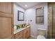 Bathroom with a wooden vanity, granite counter, and decorative framed flower pictures hanging on the wall at 11073 Newland St, Westminster, CO 80020