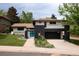 Two-story home with dark brick accents, attached garage, and landscaped front yard at 7453 E Jefferson Dr, Denver, CO 80237