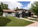 Two-story home with dark brick accents, manicured lawn, and attached carport and front patio area at 7453 E Jefferson Dr, Denver, CO 80237