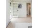 Bright hallway with a doorway to a bathroom featuring tile flooring and white trim at 7453 E Jefferson Dr, Denver, CO 80237