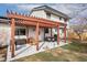 Backyard patio with pergola, outdoor dining area, and a well-manicured lawn at 11936 W Temple Dr, Morrison, CO 80465