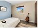 Cozy bedroom with wood laminate floors, window with a view, and a guitar next to the bed at 11936 W Temple Dr, Morrison, CO 80465