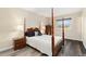Bedroom featuring a four post bed, wood laminate floors, and two bedside lamps on dressers at 11936 W Temple Dr, Morrison, CO 80465
