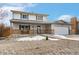 Traditional two-story home with an attached garage, covered porch and gravel landscaping at 11936 W Temple Dr, Morrison, CO 80465