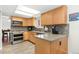 Well-lit kitchen featuring stainless steel appliances, tile backsplash, light wood cabinets, and a breakfast nook at 11936 W Temple Dr, Morrison, CO 80465