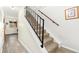 Staircase with carpeted steps, a dark handrail, and a window view down the hallway landing at 11936 W Temple Dr, Morrison, CO 80465