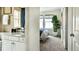 Elegant bathroom featuring a well-lit vanity and a glimpse into a bedroom with bright windows and modern decor at 13342 Blue Amber Ct, Parker, CO 80134