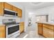 Open-concept kitchen with wood cabinets, stainless steel appliances, and an adjacent living area at 1320 Laurenwood Way, Highlands Ranch, CO 80129