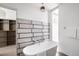 Bright bathroom featuring modern fixtures, a soaking tub, and a walk-in closet at 1467 Delgany St # 1, Denver, CO 80202