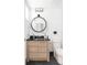 Modern bathroom with round mirror, light wood vanity and black and white mosaic tile floor at 1467 Delgany St # 1, Denver, CO 80202