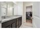 Bathroom featuring double granite vanity and walk-in closet at 7210 Fall River Cir, Frederick, CO 80530