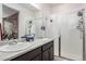 Bathroom featuring a double sink vanity with white tile and an enclosed shower at 17217 E Exposition Dr, Aurora, CO 80017