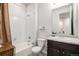 Bright bathroom with white tiled shower/tub combo and dark vanity with a large mirror at 17217 E Exposition Dr, Aurora, CO 80017