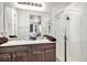 Bathroom featuring dual sinks, dark wood cabinets, and a glass-enclosed shower at 17217 E Exposition Dr, Aurora, CO 80017