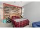 Unique bedroom featuring a wooden accent wall, cozy bed, and a comfortable atmosphere at 17217 E Exposition Dr, Aurora, CO 80017