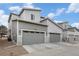 Modern townhome exterior featuring two-car garages, gray siding, and well-maintained landscaping at 17217 E Exposition Dr, Aurora, CO 80017