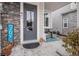 Inviting front porch with stone veneer, gray door, and seating area at 17217 E Exposition Dr, Aurora, CO 80017